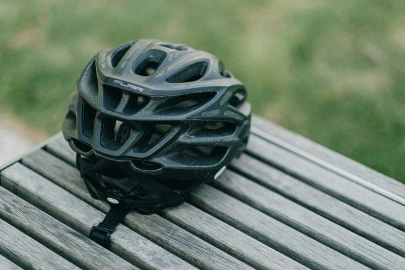 Un casco de bicicleta sobre una banca de madera